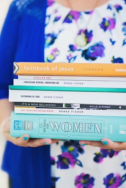 woman holding biblical books